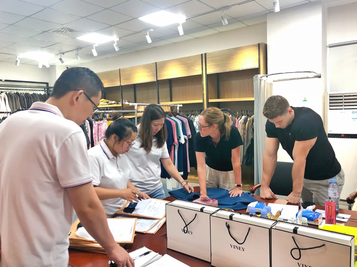 Customers and SALATI team members reviewing garment samples and notes together