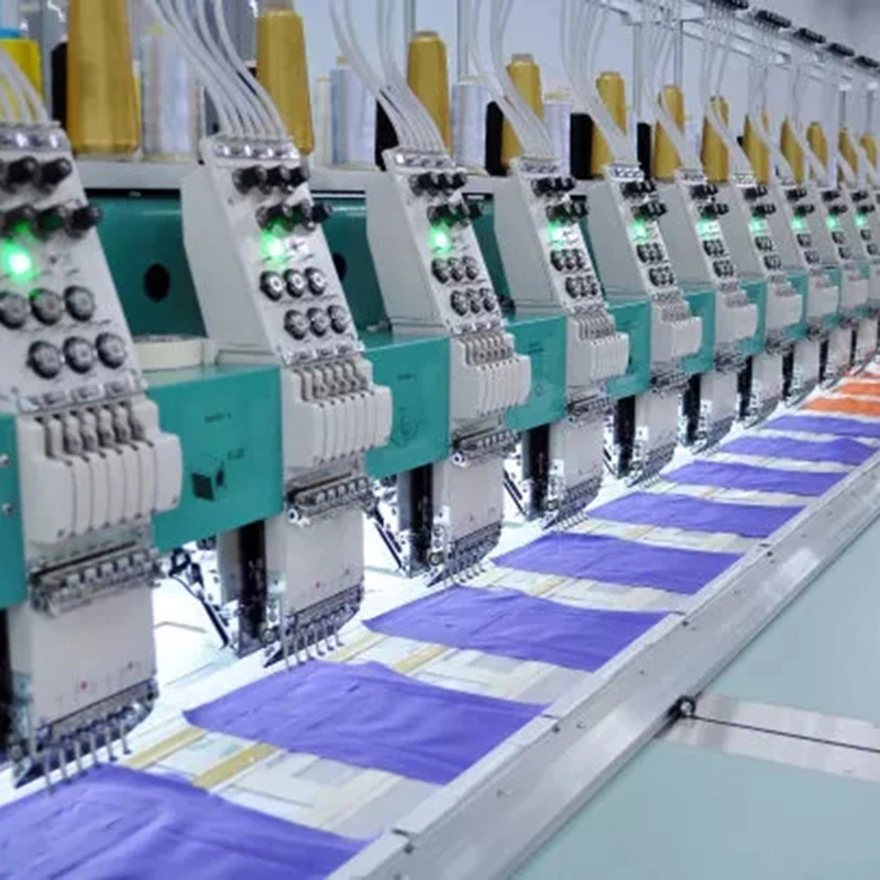 A row of embroidery machine heads working over hooped fabric.