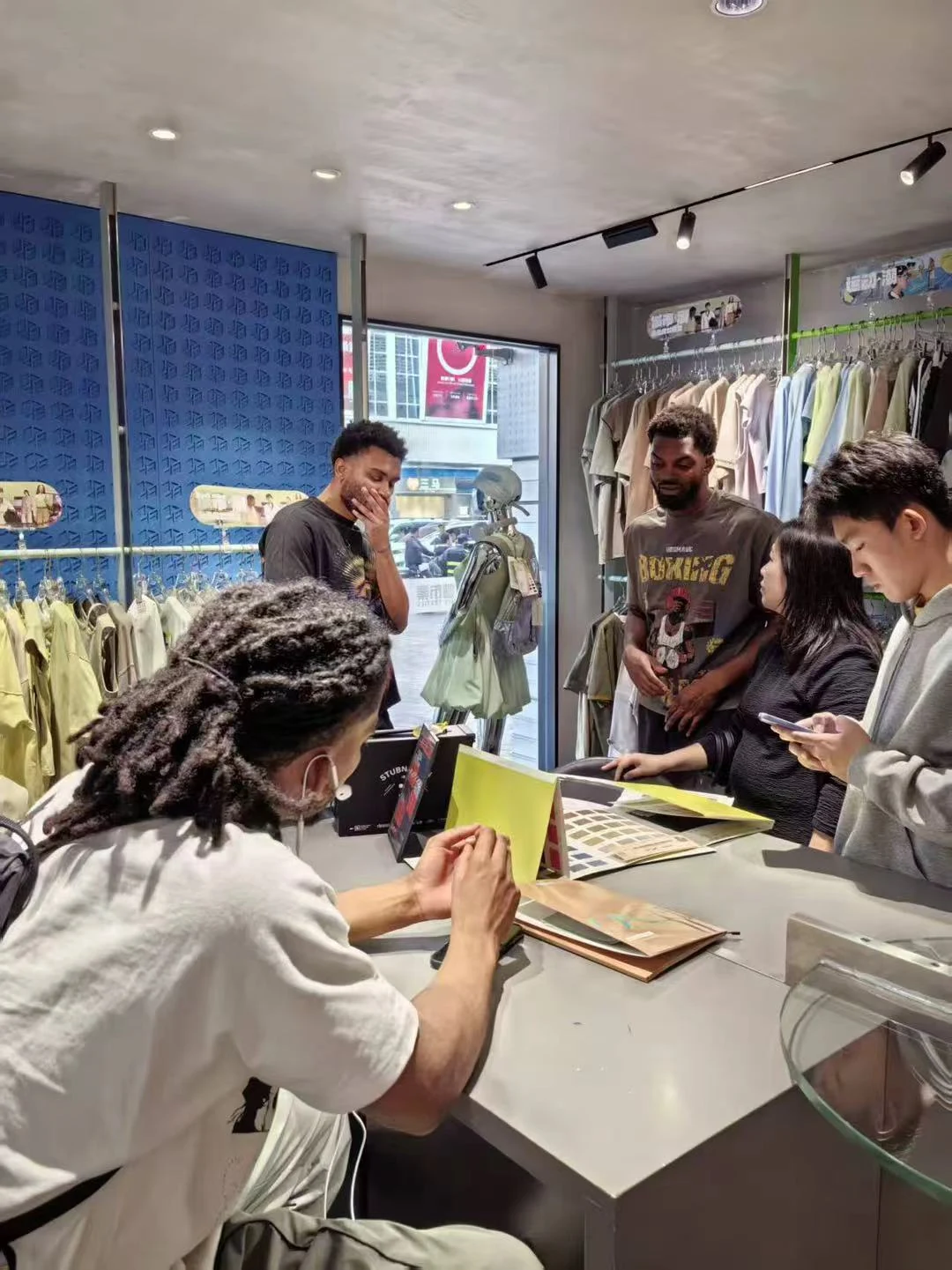 Customers and the SALATI team comparing material reference books at a showroom table