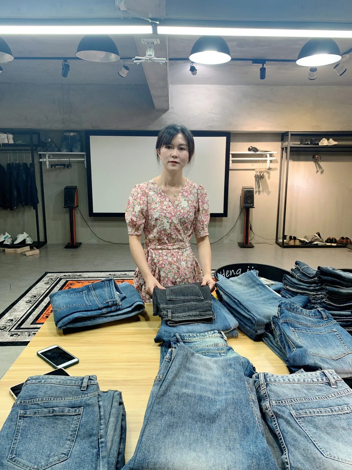 SALATI — Garment inspector reviewing denim jeans stitch quality with a checklist
